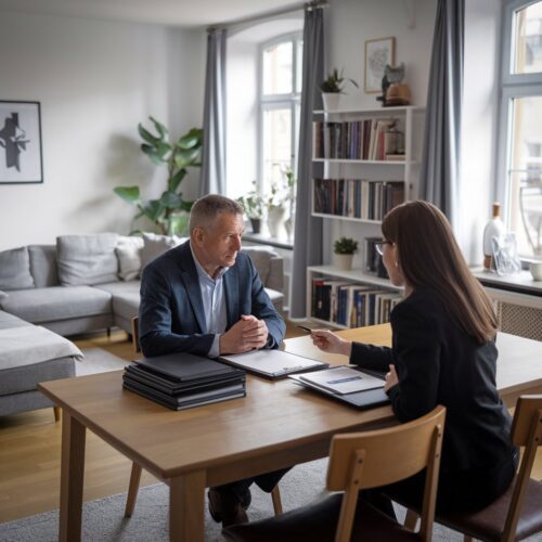 Mann und Frau besprechen rechtliche Dokumente in einem modernen Wohnzimmer, umgeben von Finanzen und Gesetzen.
